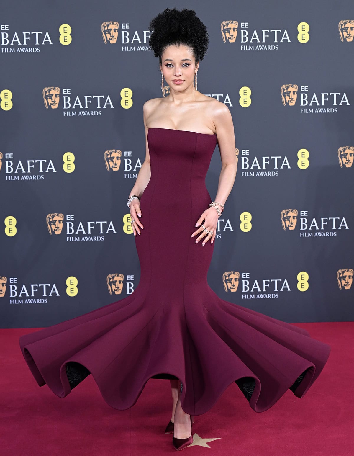 Chase Infiniti matches her pumps with her architectural Louis Vuitton gown featuring a form-fitting strapless bodice and a sculptural, wave-like ruffle hem