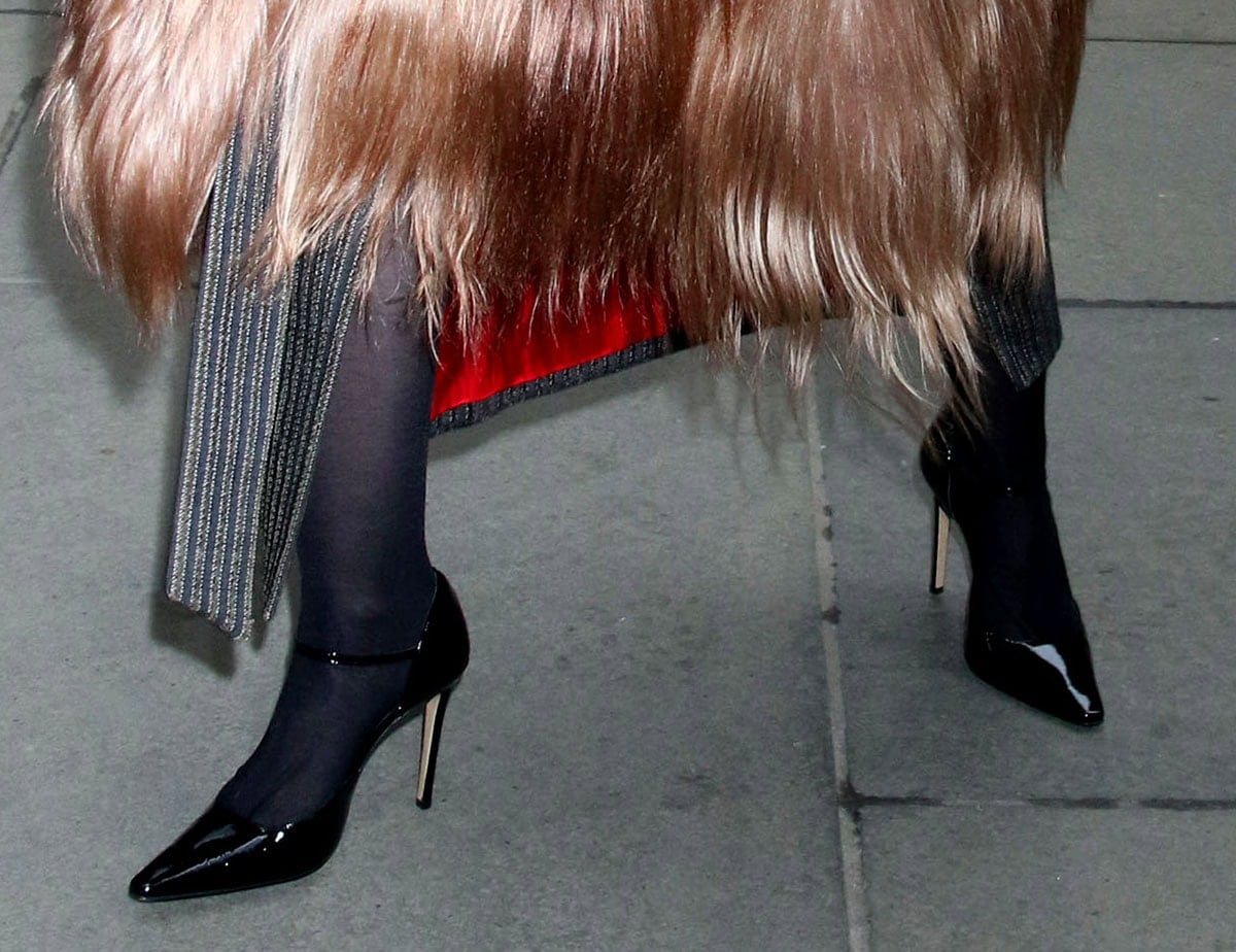 Dove Cameron completes her chic office look with sheer black stockings and shiny black patent Mary Jane pumps