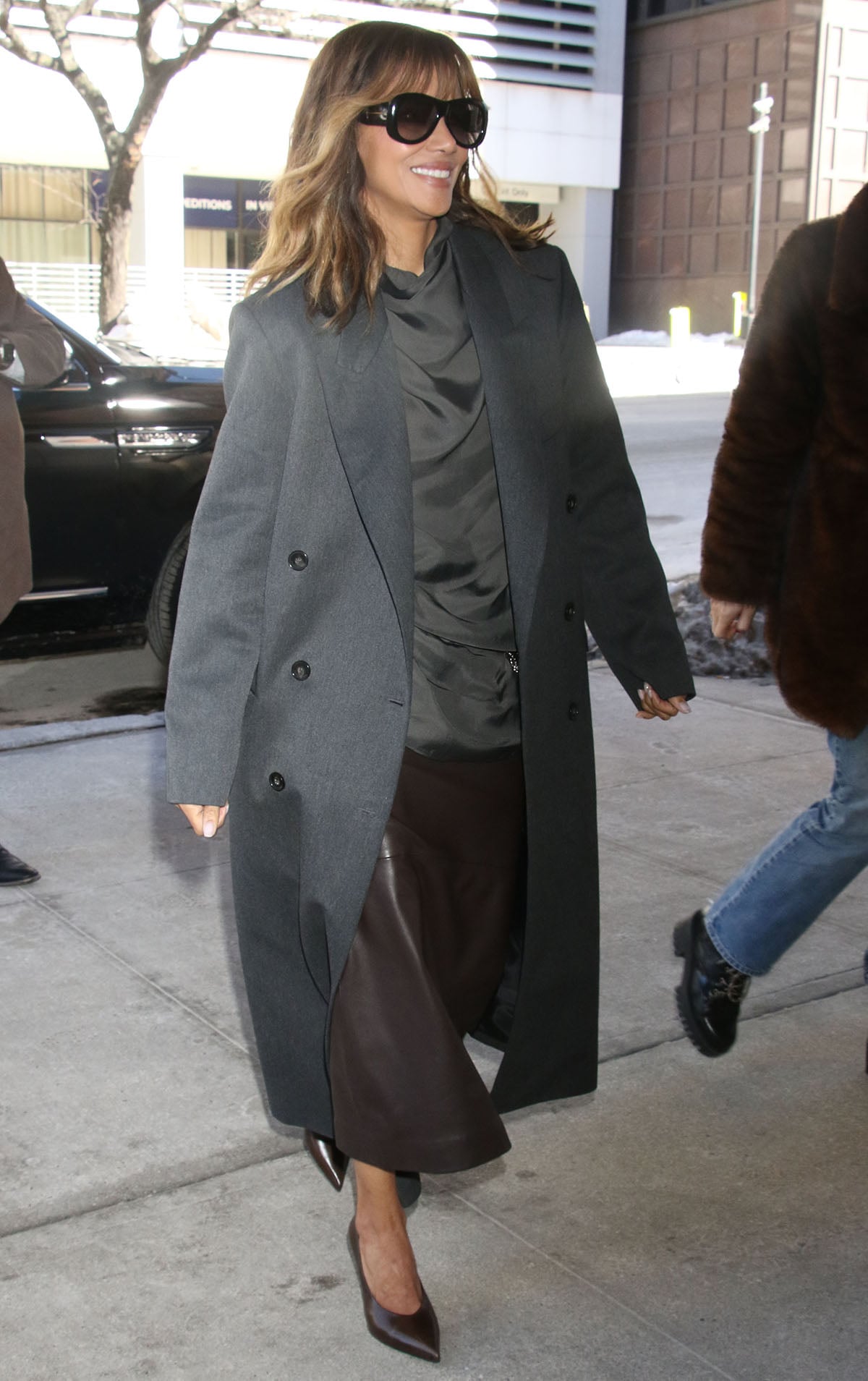 Halle Berry drops by The Drew Barrymore Show in a gray Róhe double-breasted coat with a neutral-colored dress underneath