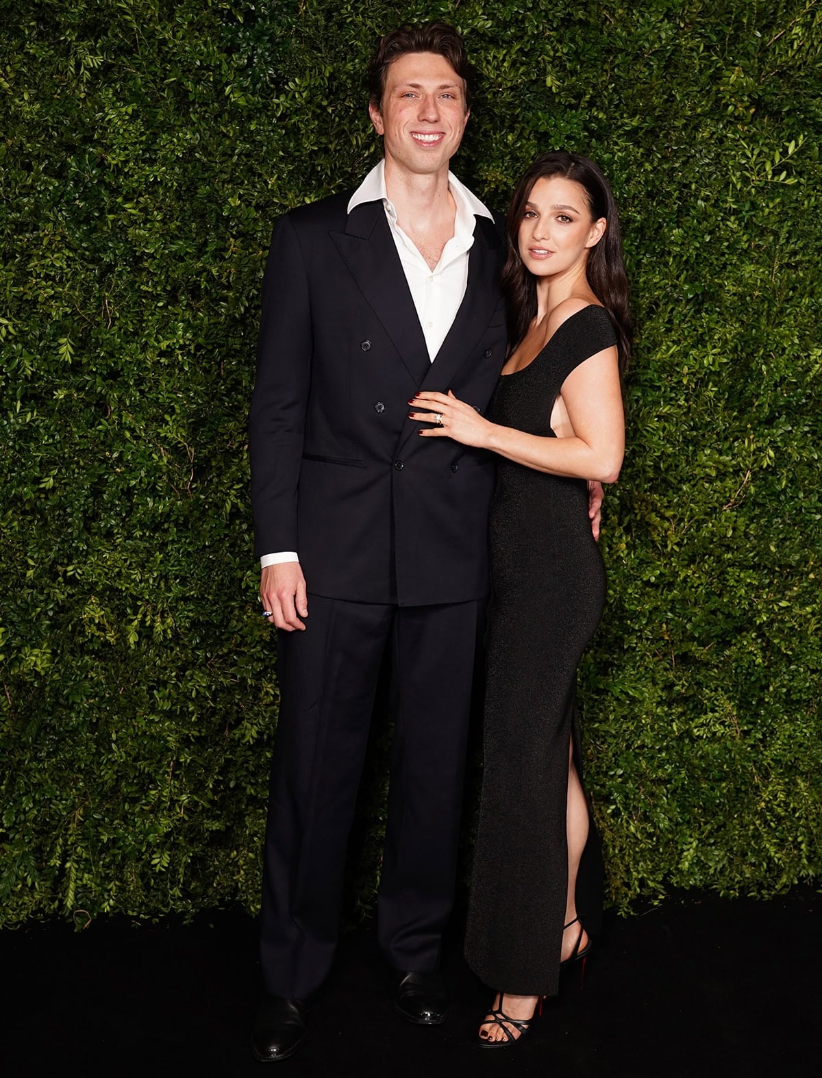 Marisa Abela, with husband Jamie Bogyo, stuns in a form-fitting off-the-shoulder black maxi dress