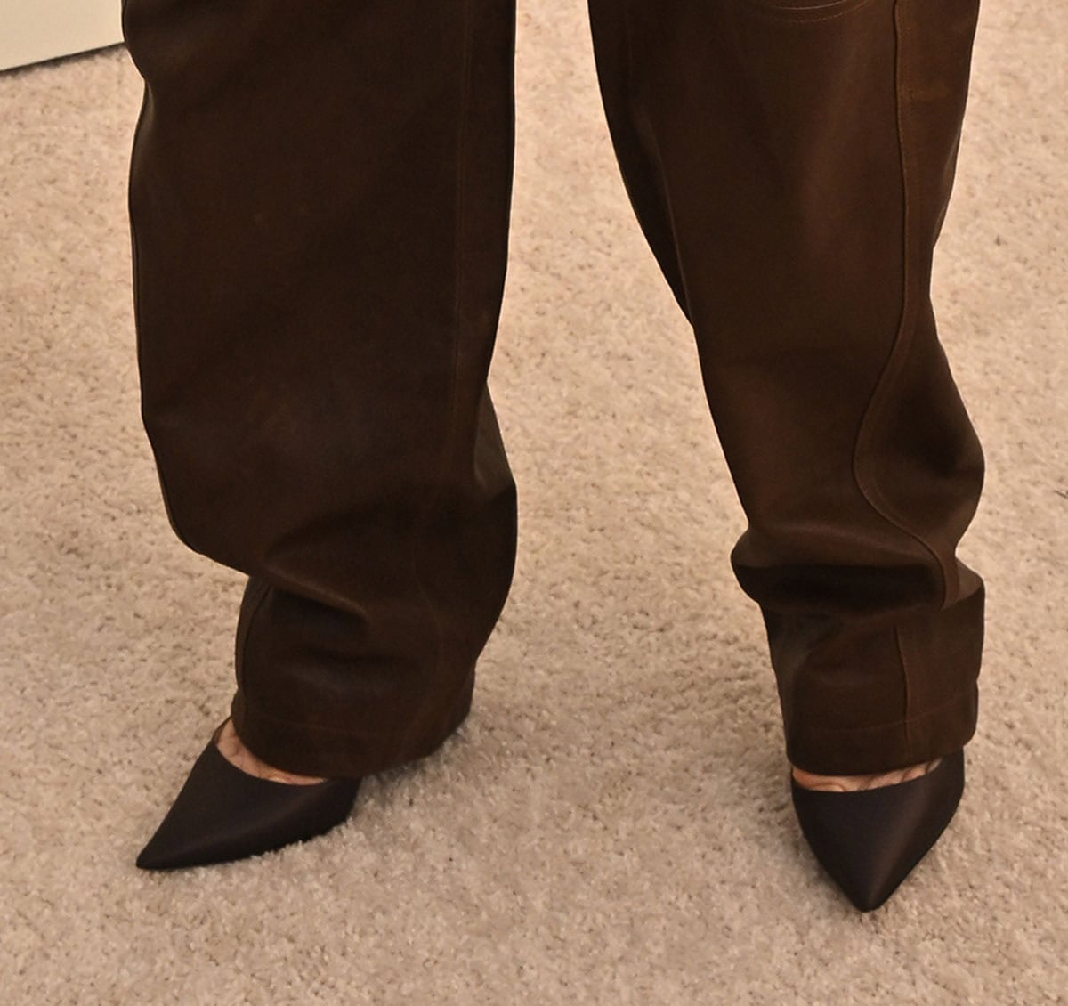 Jessica Biel slips into a pair of pointed-toe brown pumps, matching her brown ensemble