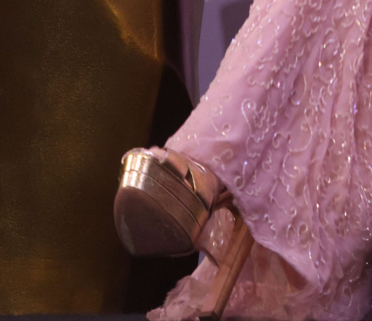 Kate Hudson pairs her pink dress with gold sandals featuring double platforms, thick high heels, and crisscrossing thick straps