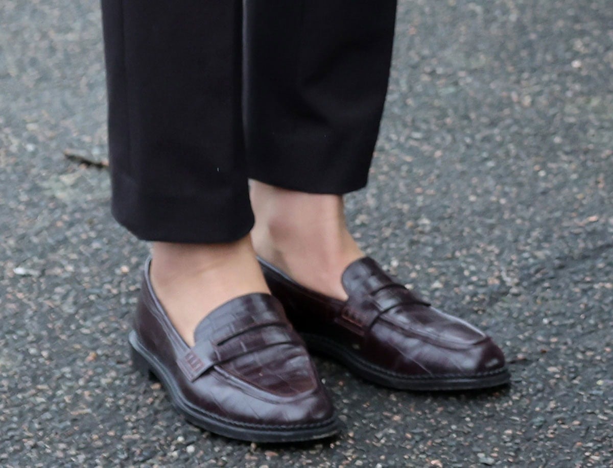 Kate Middleton pairs her brown-and-blue suit with reddish-brown Boden “Nya” penny loafers with a croc-embossed finish