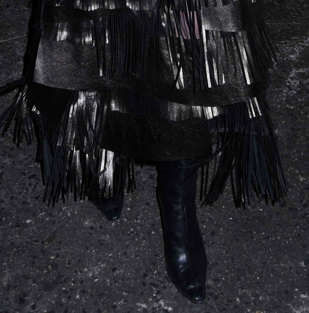 A closer look at Lili Reinhart’s sleek black boots reveals how their pointed toes and polished leather ground the movement of her dramatic fringed skirt with a sharp, equestrian-inspired finish