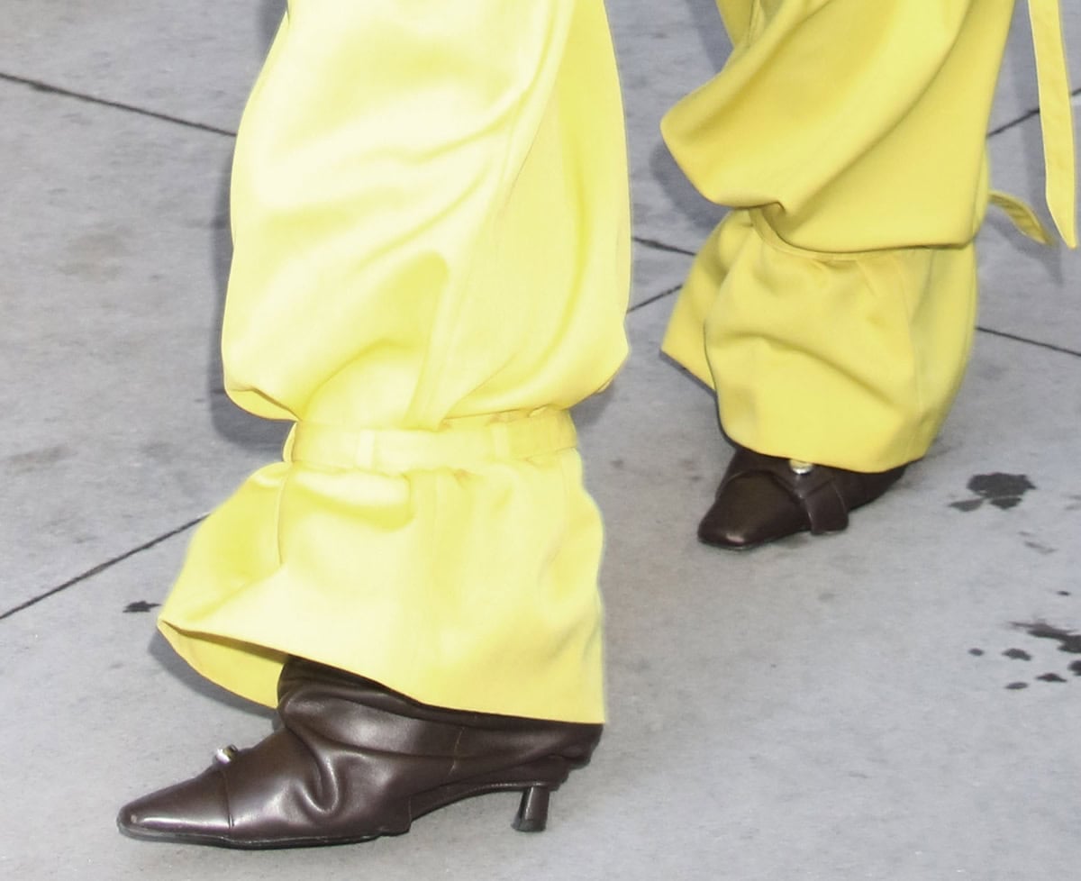 Lisa Rinna visits The View in brown The Attico “Juno” boots featuring slouchy shafts, a buttoned strap across the vamp, and slim heels