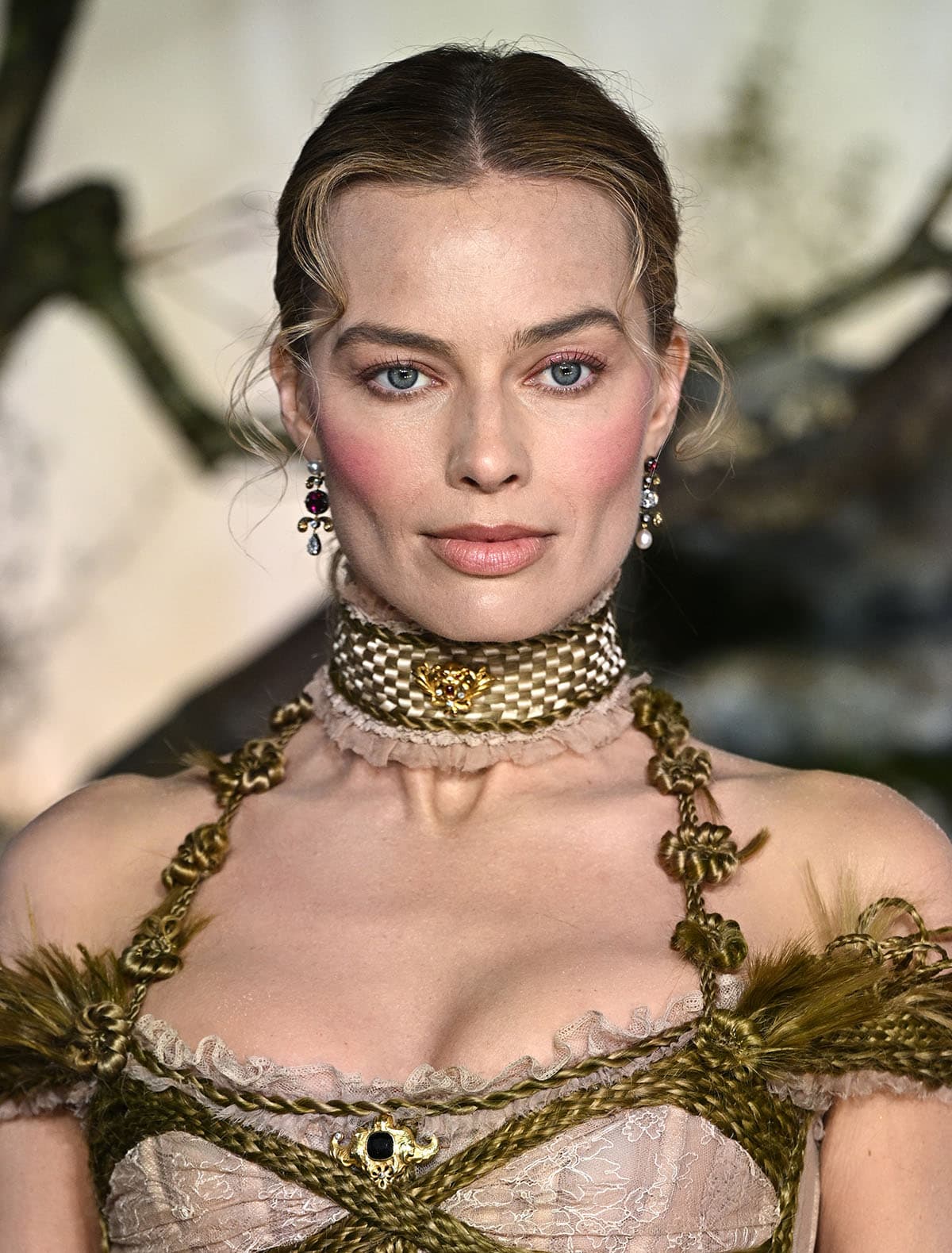 Margot Robbie further styles her already busy look with vintage Boucheron brooches and Jessica McCormack jewels
