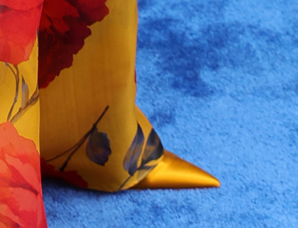 Nina Dobrev offers a glimpse of her metallic gold satin pointed-toe pumps