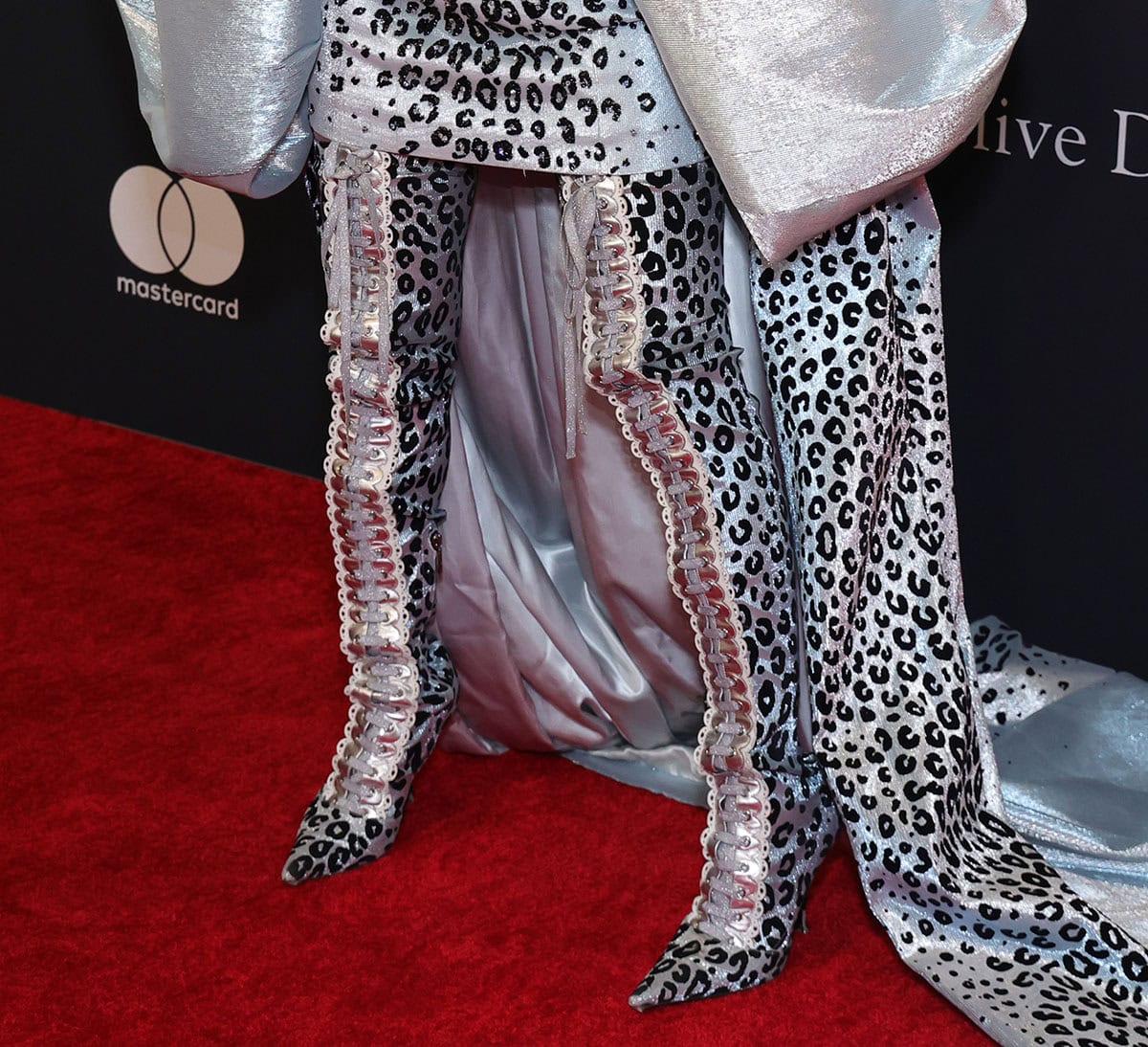 Rei Ami commands attention in icy blue leopard-print thigh-high boots with lace-up fastening and silver and white trims