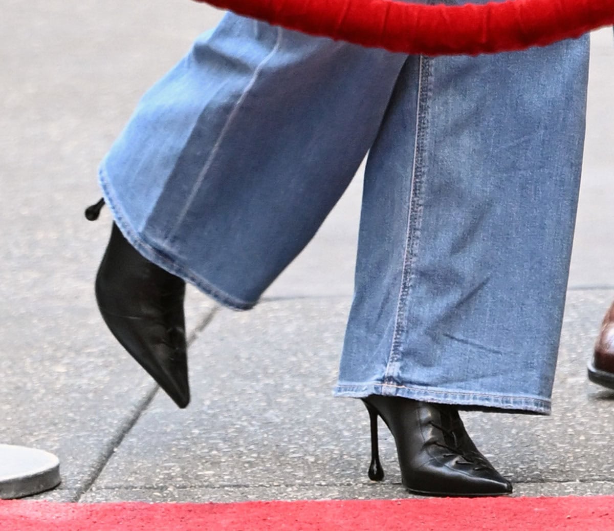 Sydney Sweeney completes her '90s denim look with the Jimmy Choo “Scarlett” boots with lace-up front ties, pointed toes, and drop heels