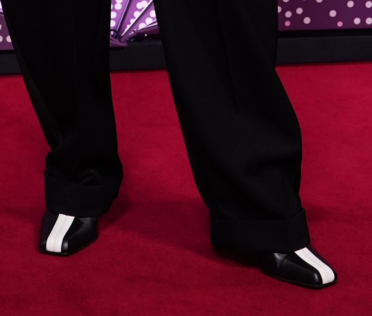 Tilda Swinton wears a striking pair of Chanel shoes in dominant black leather with a bold white stripe along the center, square toes, and heels