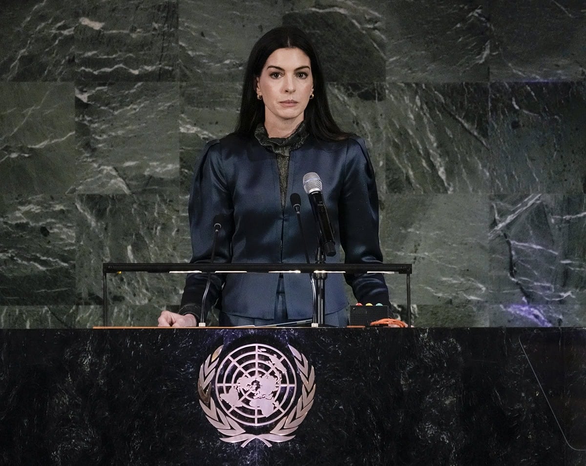Anne Hathaway keeps her makeup simple and styles her hair straight, cascading down her back