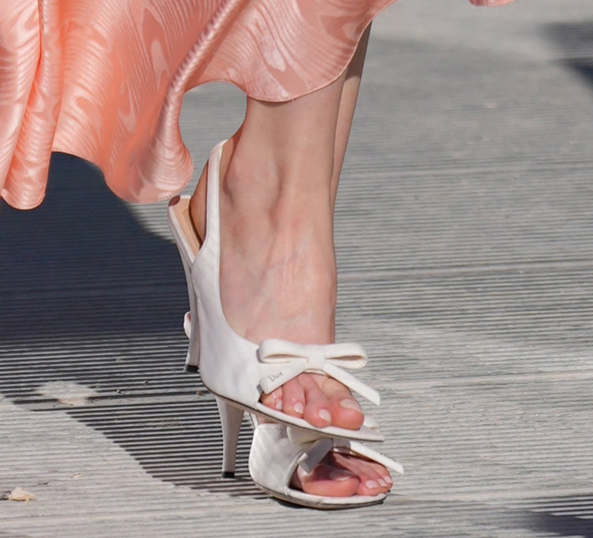 Anya Taylor-Joy slips into the Dior Bow Heeled Slingback Sandals from Jonathan Anderson’s Spring 2026 collection, featuring a bow across the front strap with a small gold-tone Dior signature, a D-shaped sole, and a slingback strap