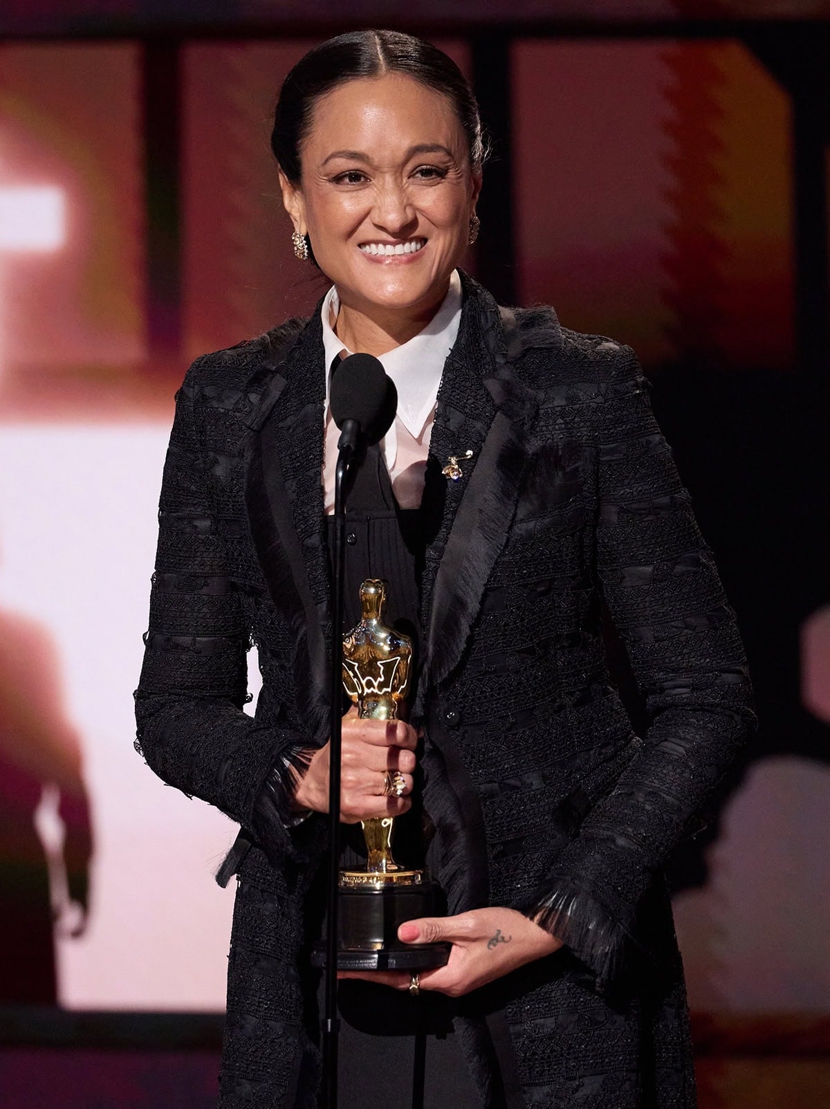 Cinematographer Autumn Durald Arkapaw celebrates her historic Best Cinematography win at the 98th Academy Awards on March 15, 2026, wearing a head-to-toe Thom Browne ensemble as she accepts her Oscar onstage