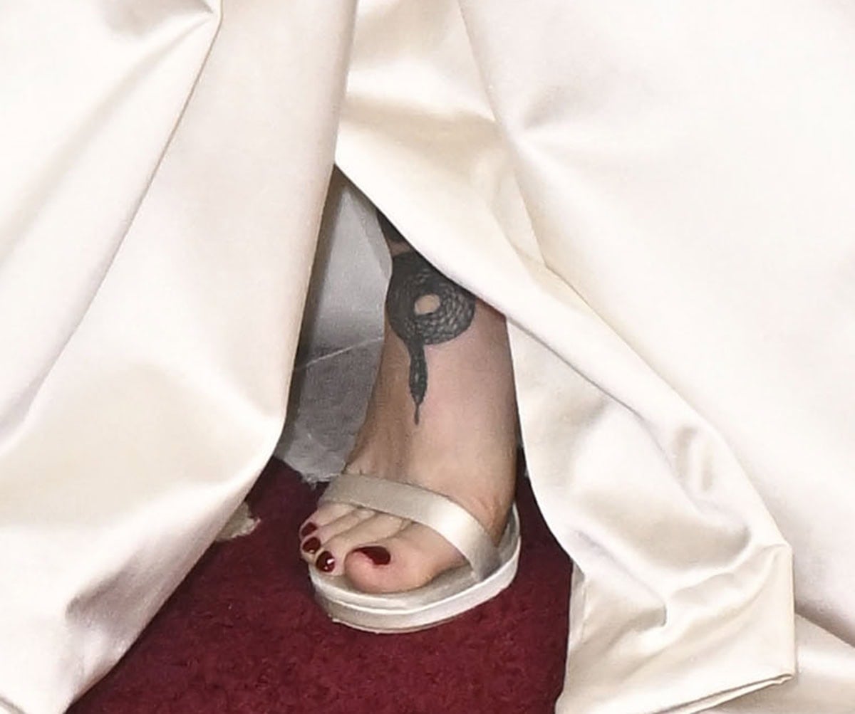 Dove Cameron showcases her red pedicure and foot tattoo in the off-white satin Jimmy Choo “Moza” sandals