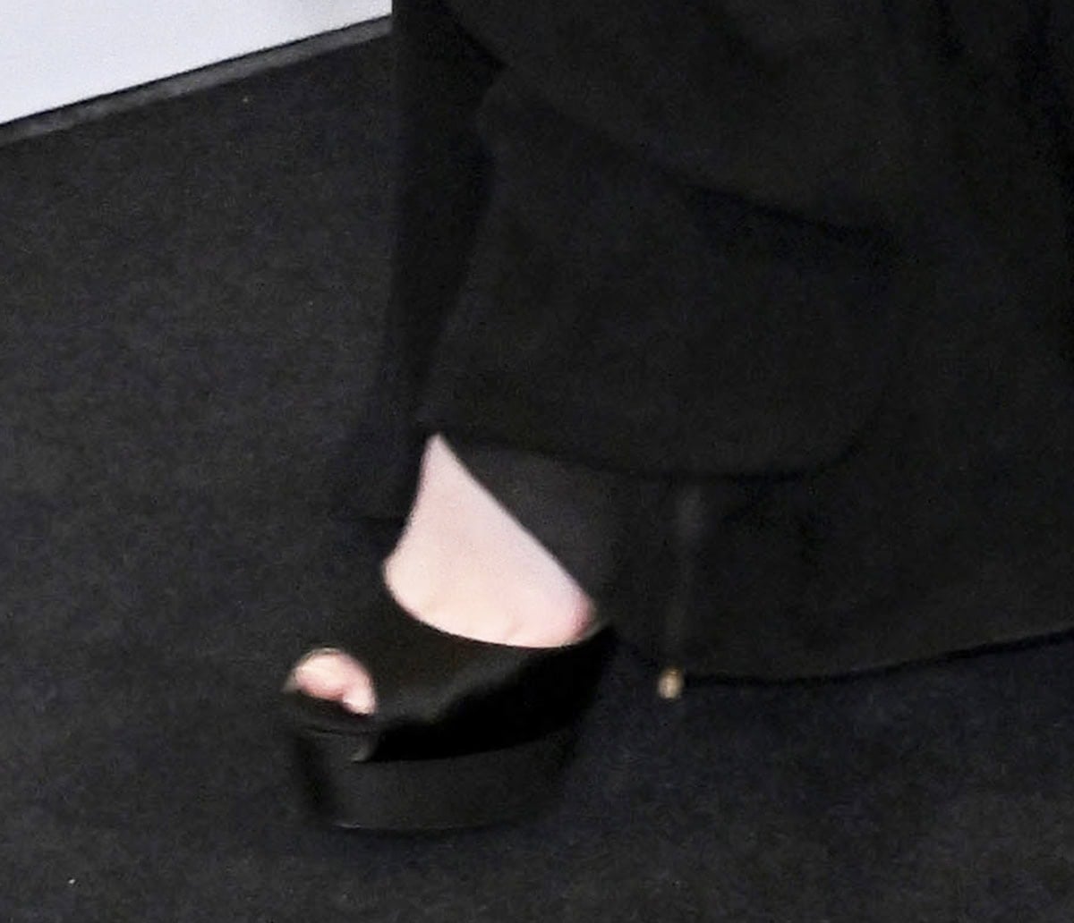 Elle Fanning opts for head-to-toe black, slipping into a pair of black satin peep-toe platform shoes