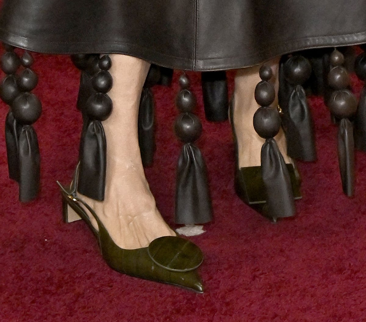 Casting director Francine Maisler embraces art deco fashion with the Jacquemus “The Low Duelo” slingbacks in dark khaki tanned eel leather with Rond-Carré accents at the toes