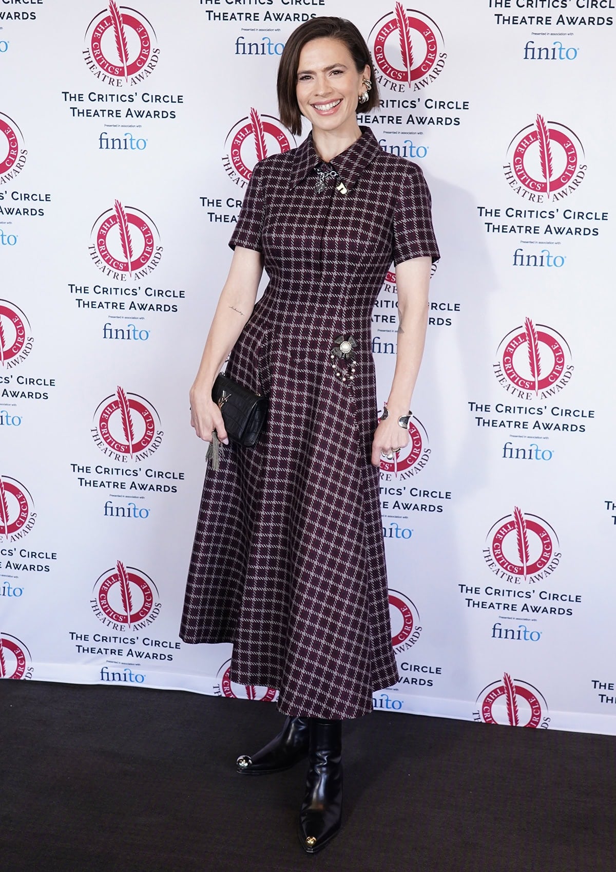 Hayley Atwell pairs her striking Western boots with an Emilia Wickstead dress in rich red-and-black Shetland houndstooth pattern