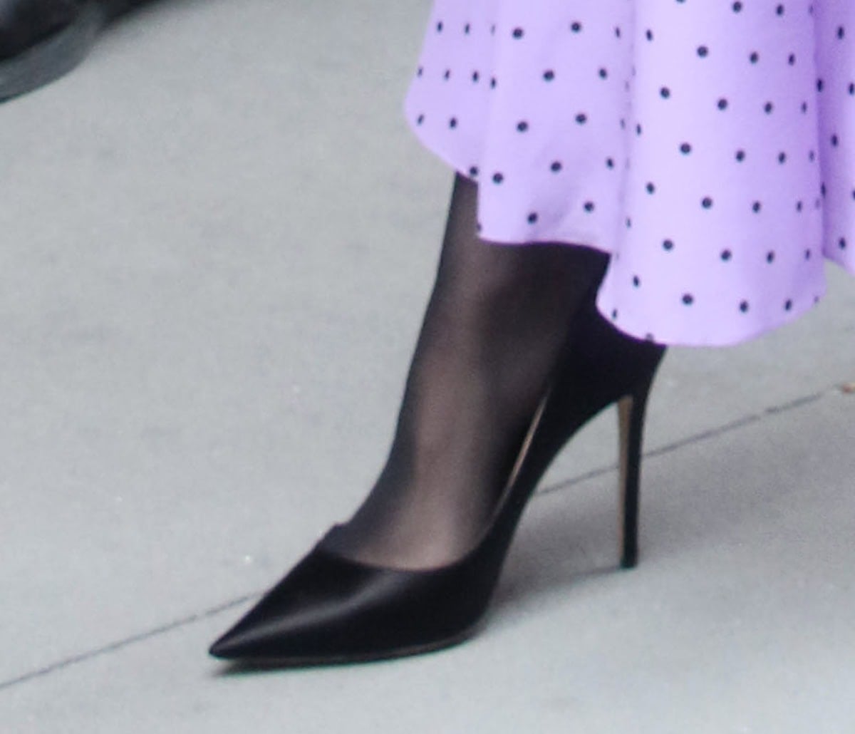 Kathryn Newton steps out in sleek black satin Rodo pumps, featuring sharply pointed toes and slender stiletto heels