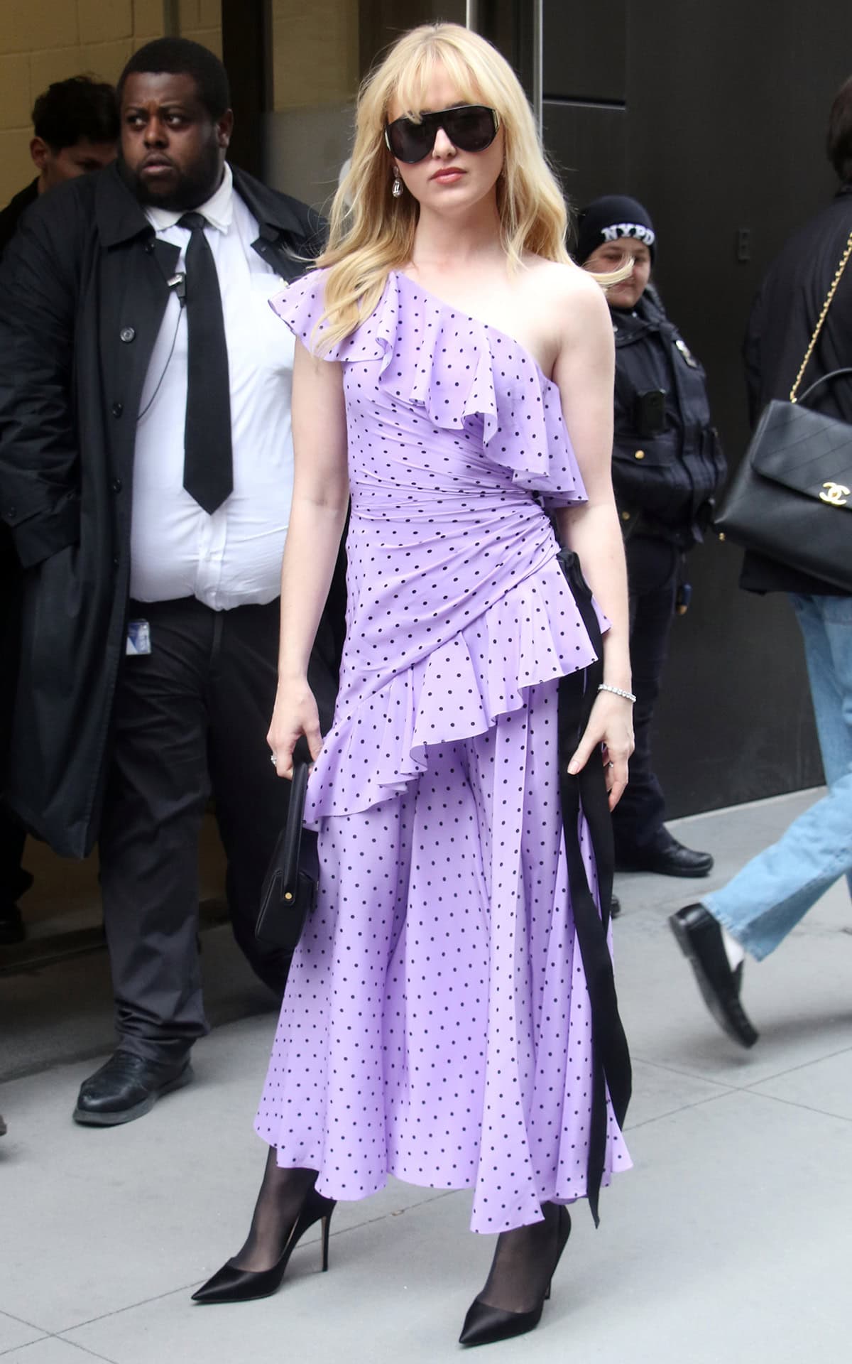 Kathryn Newton pairs her black pumps with sheer black tights and a flamenco-style purple polka-dot one-shoulder dress with ruffled accents by Carolina Herrera