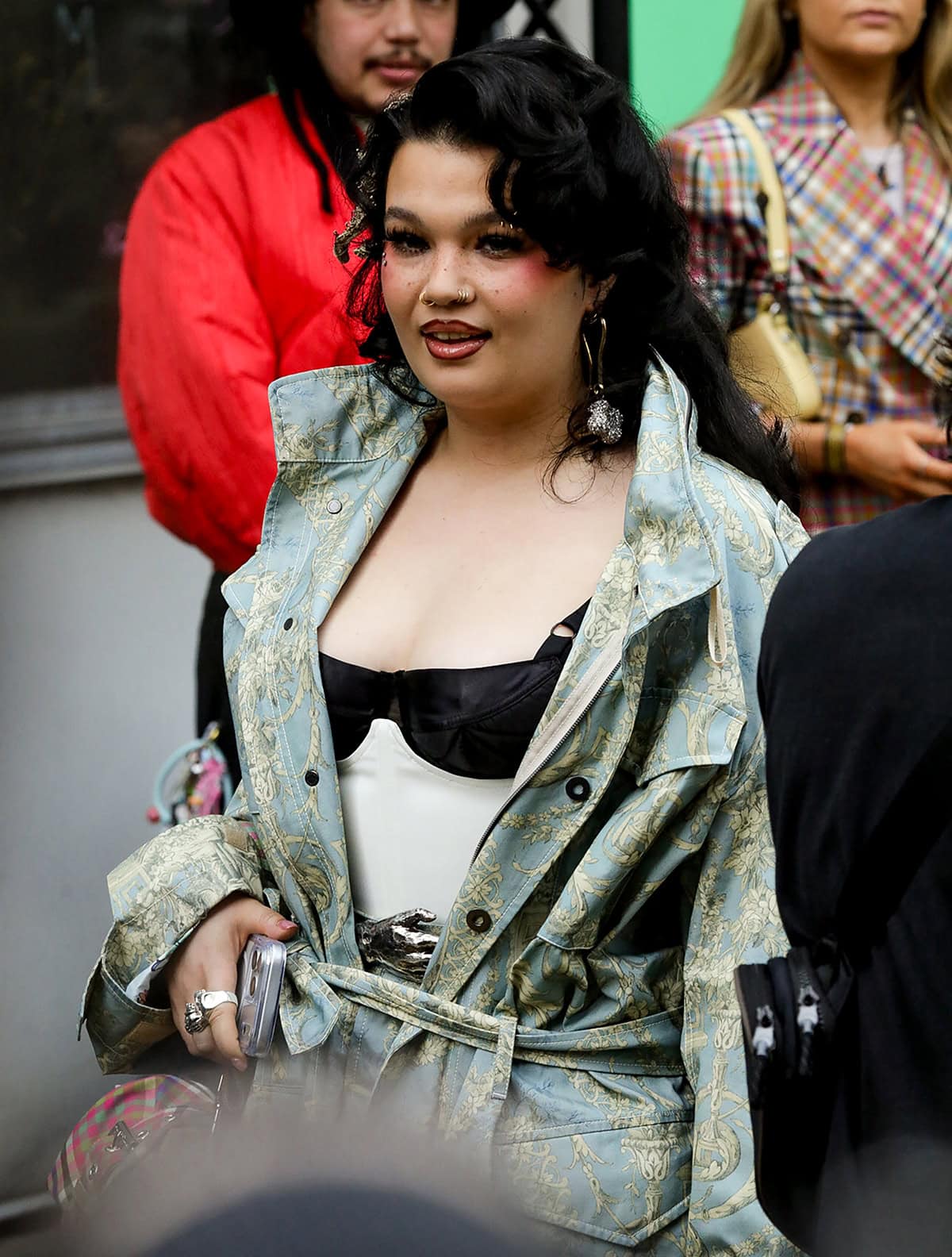 Lola Young pairs her gingham mules with a Toile de Jouy printed jacket, matching cropped pants, and a black-and-white corset