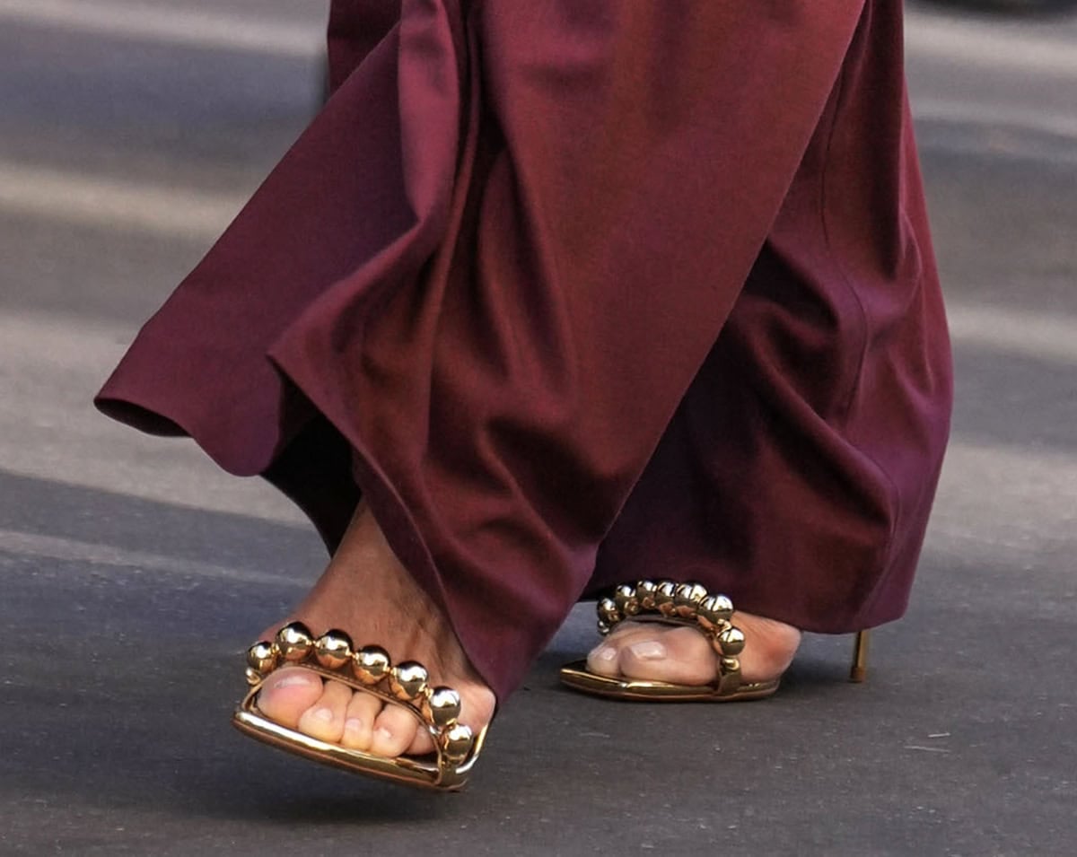 Molly Sims brings metallic shine to the front row with her Camilla Gabrieli “Olivia” sandals in gold-tone leather with sculptural bauble spheres decorating the front and ankle straps and a large bauble at the heel