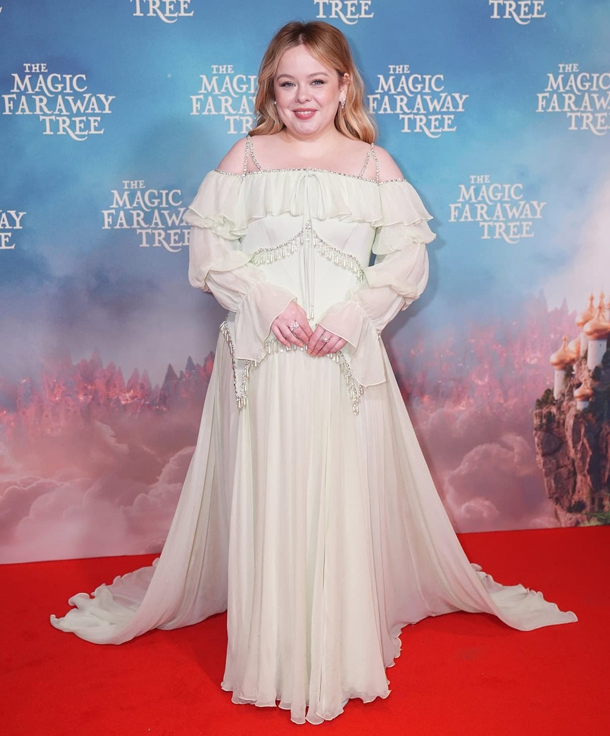 Nicola Coughlan channels her The Magic Faraway Tree character, Silky, in a soft mint green Georges Hobeika dress with an off-the-shoulder neckline, embellished shoulder straps, ruffles, and dangling embellishments