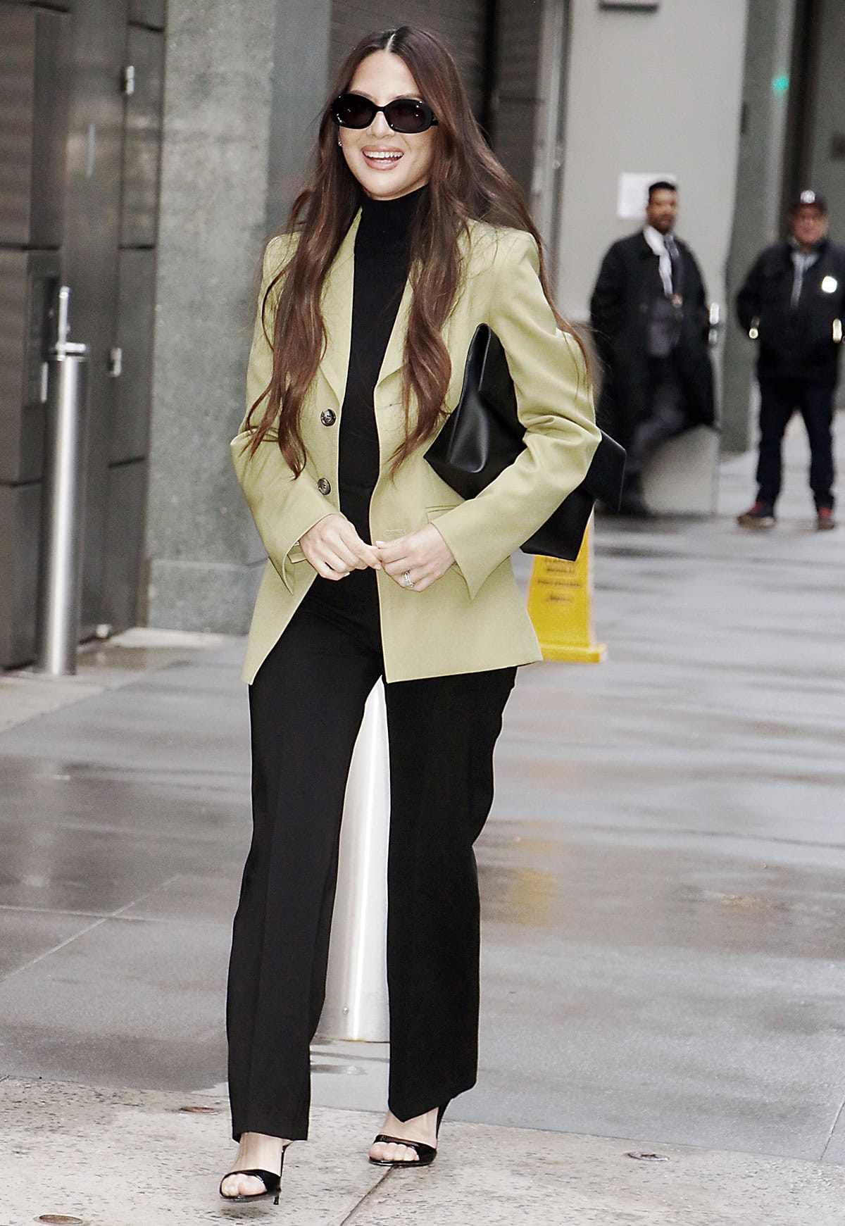 Olivia Munn styles her black patent Paris Texas mules with slightly flared trousers, a fitted turtleneck, and a matcha-green Ami jacket for a sharp, modern city look
