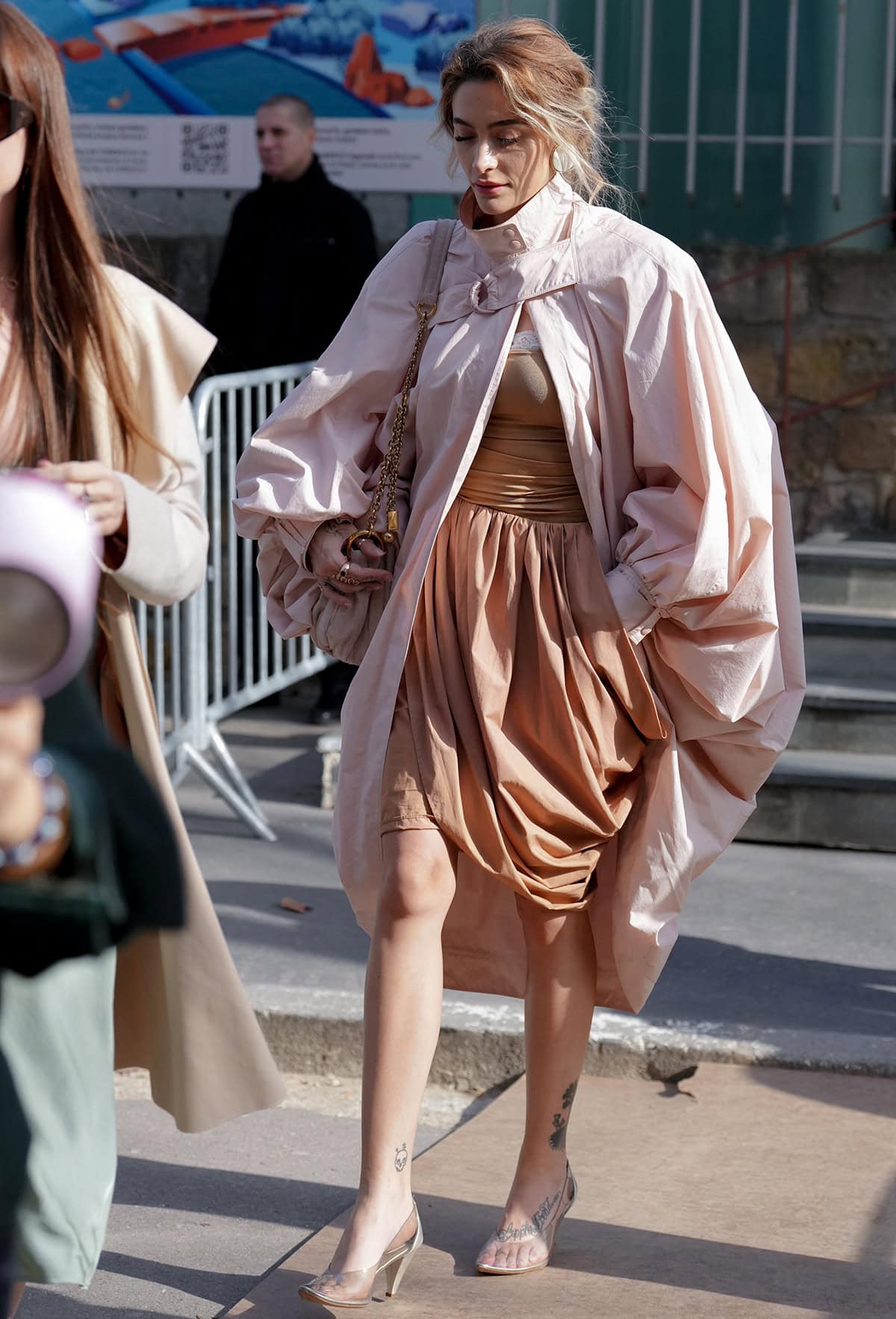 Paris Jackson pairs her clear Chloe pumps with a lace-trimmed ruched bodysuit, a knee-length wrap skirt, and an oversized pink coat