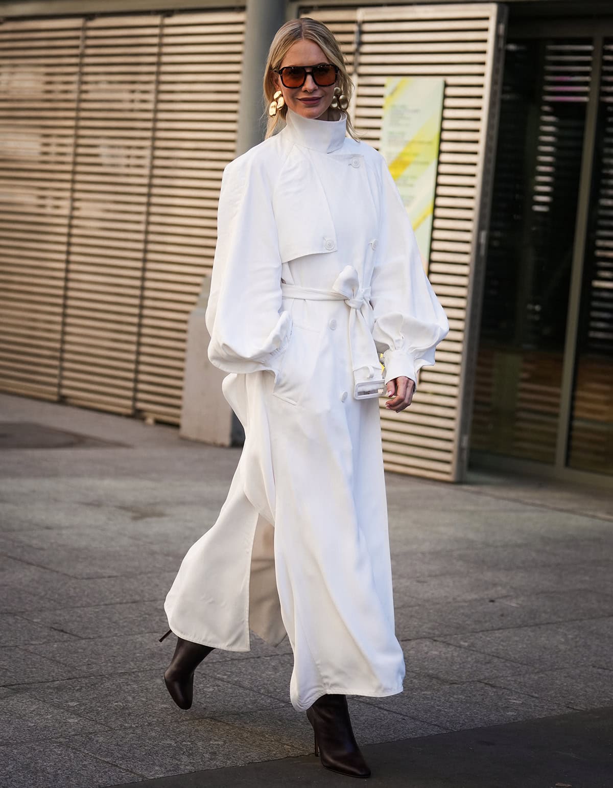Poppy Delevingne completes her boho look by pairing her brown boots with a flowy white coat dress by Zimmermann