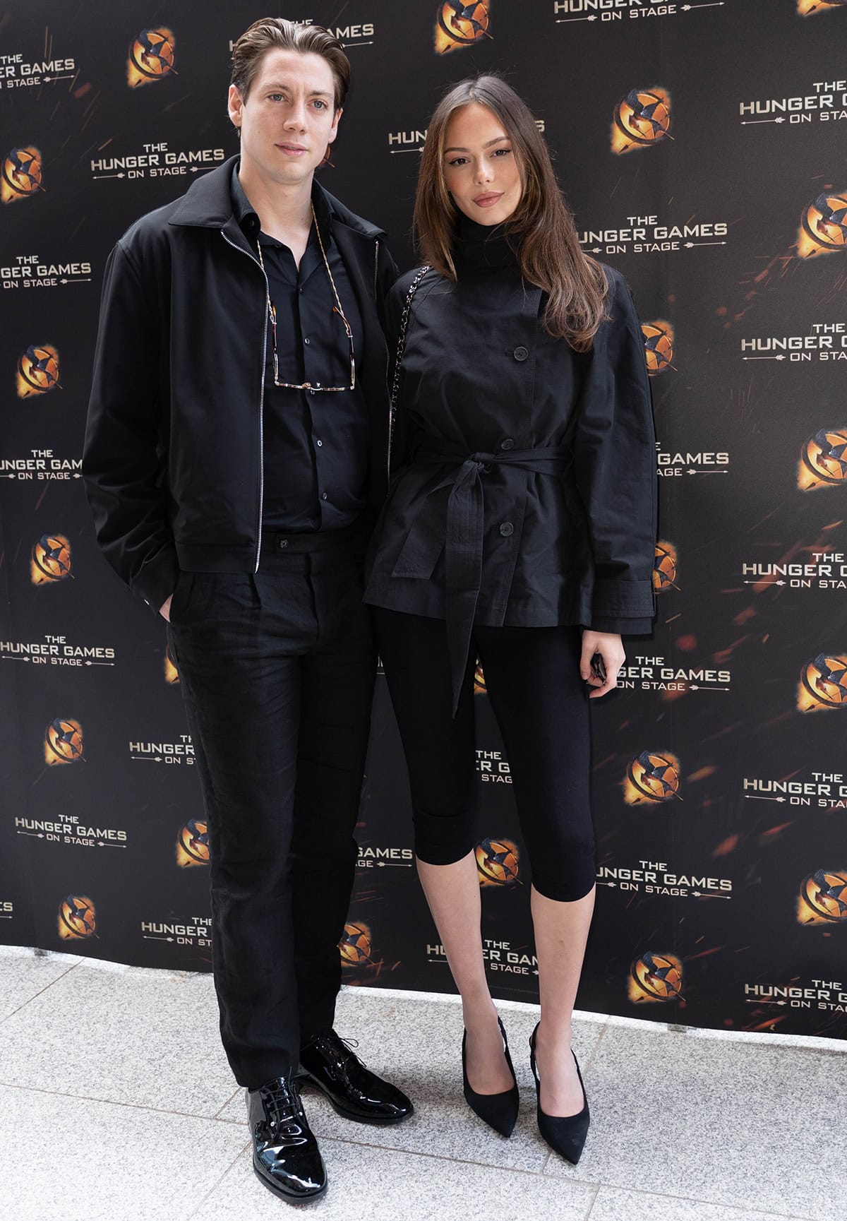 Alice Vanderpump, joined by her husband Sam Vanderpump, pairs her pointed black slingback pumps with a cinched tie-waist jacket and sleek capri pants for a modern, all-black look