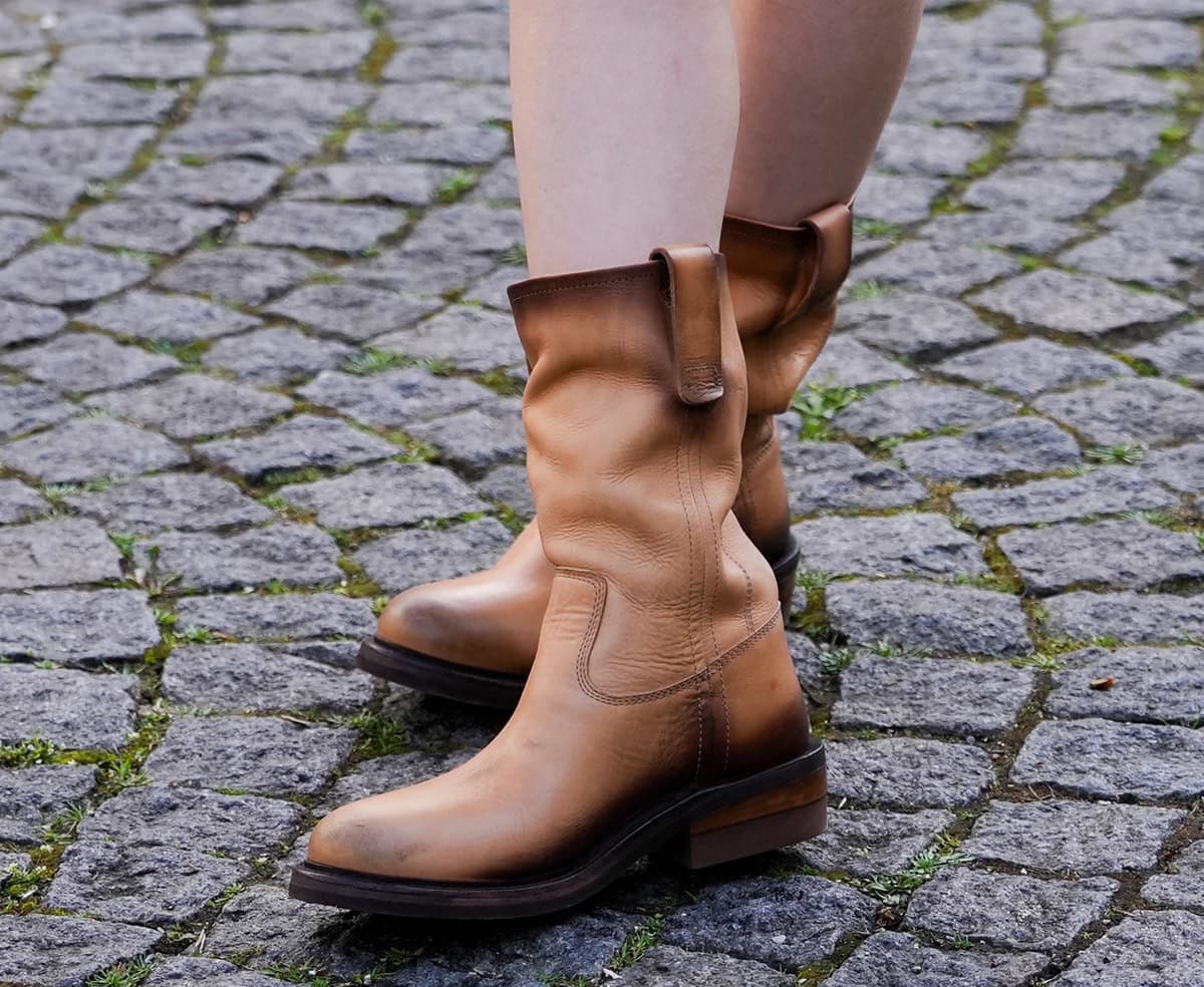 Momo embraces boho style with her burnished tan leather ankle boots with wide, slouchy shafts