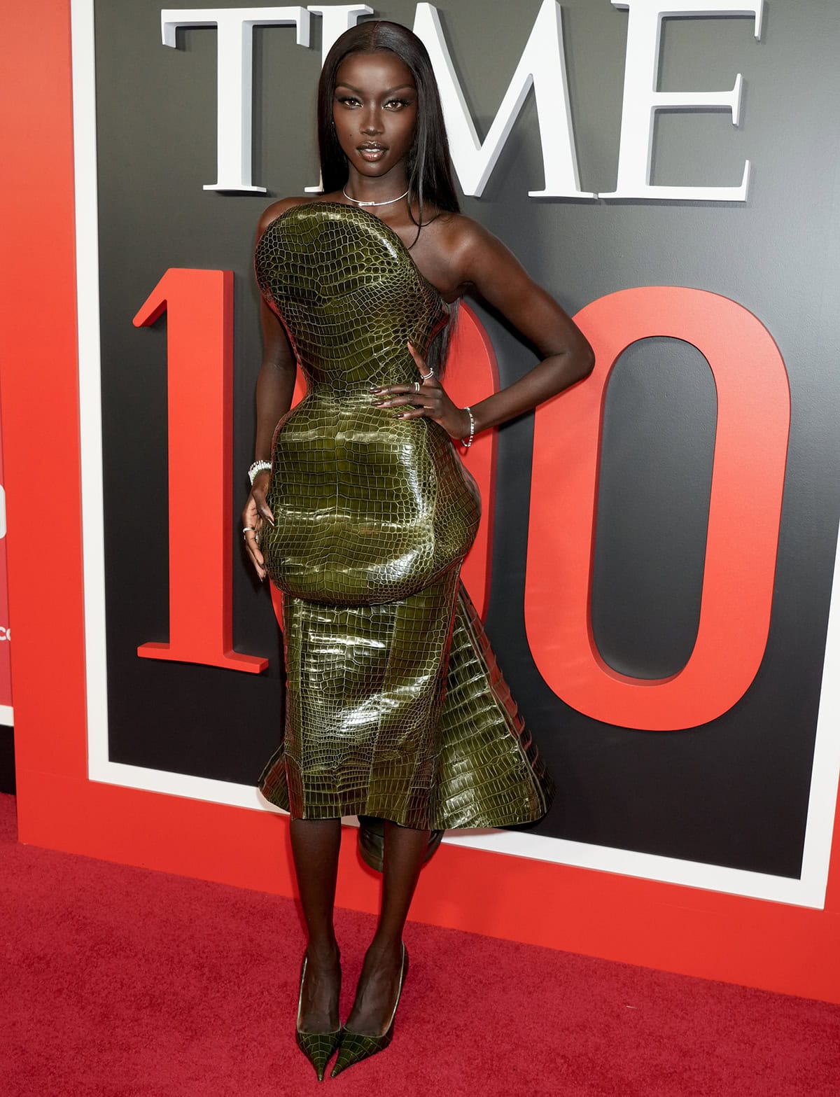 Anok Yai keeps her look coordinated, pairing her croc pumps with a glossy croc-embossed, structured dress by Ashi Studio