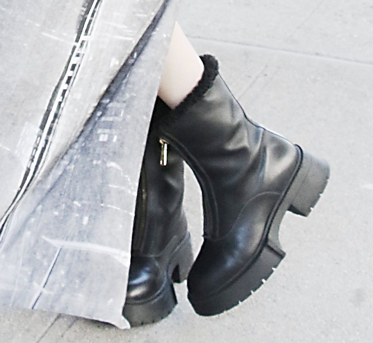 Chloe East adds edge to her look with the Coach “Leah” boots featuring a zipped front and genuine black shearling-lined collar