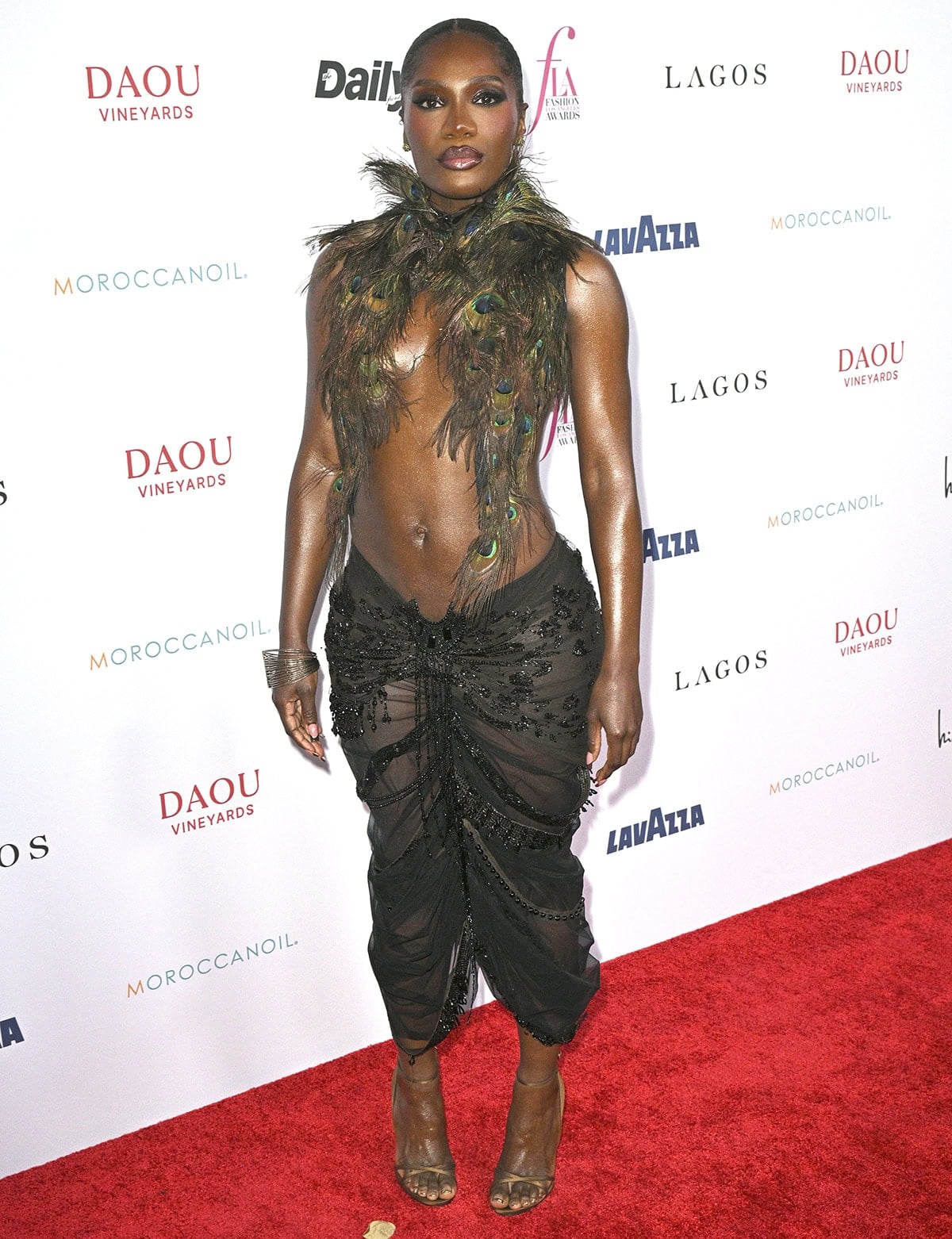 Doechii embraces a bohemian, festival-ready vibe in Dilara Findikoglu's peacock top and a sheer black skirt with crystal embellishments