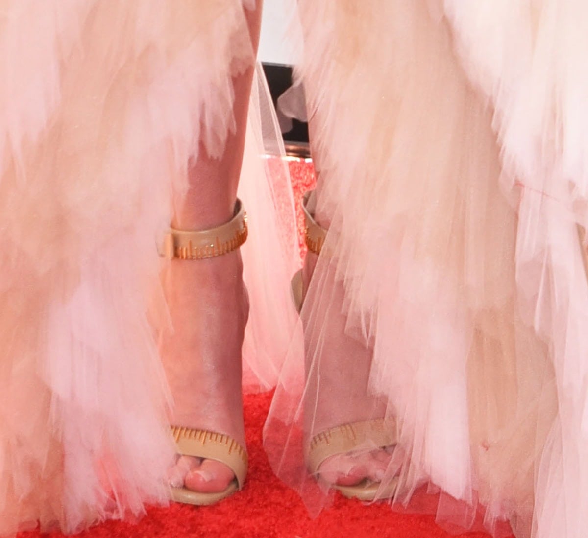 Emily Blunt opts for Schiaparelli's “Measuring Tape” heels in nude leather featuring a gold ribbon meter design