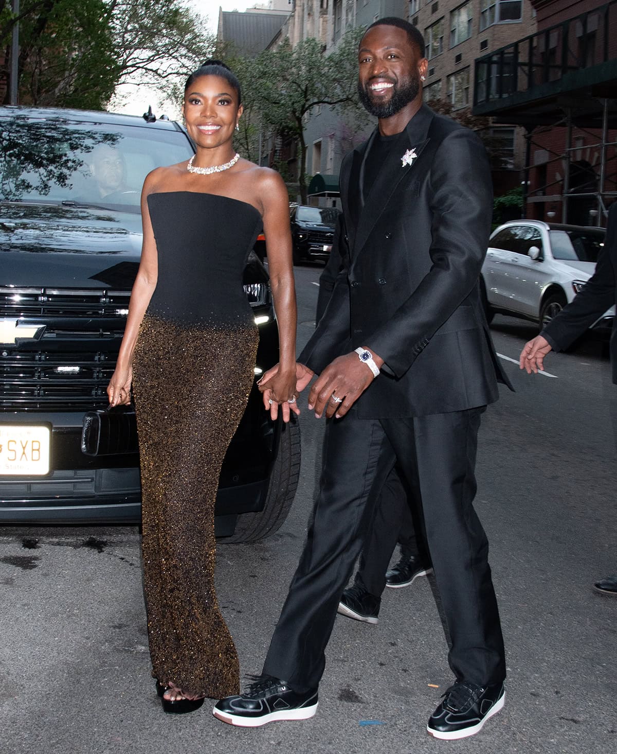 Gabrielle Union, with her husband Dwayne Wade, keeps it simple in a Salih Balta dress, featuring a black strapless bodice and a glittery gold beaded column skirt, finished with a Tiffany & Co. turtle-shell motif necklace