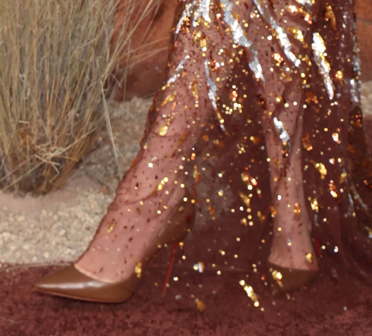 Hunter Schafer slips into a pair of brown Christian Louboutin “Iriza” pumps with a sexy d'Orsay silhouette and pin-thin stiletto heels