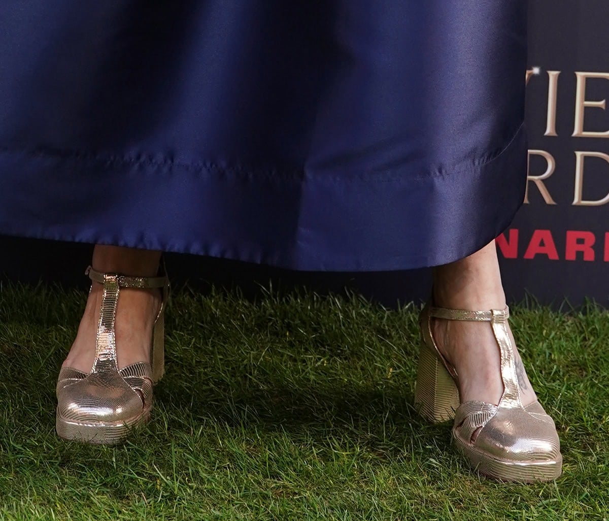 Julie Hesmondhalgh shines in the Esska “Chaza” pumps in textured metallic leather with platforms, a T-bar strap, and block heels