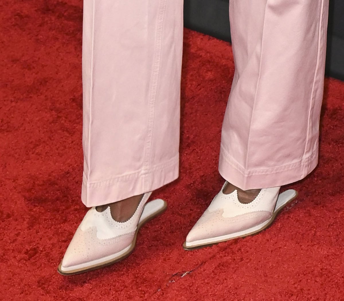 Katherine LaNasa slips into a pair of pink-and-white Thom Browne pumps with brogue perforations, wingtips, and horizontal heels