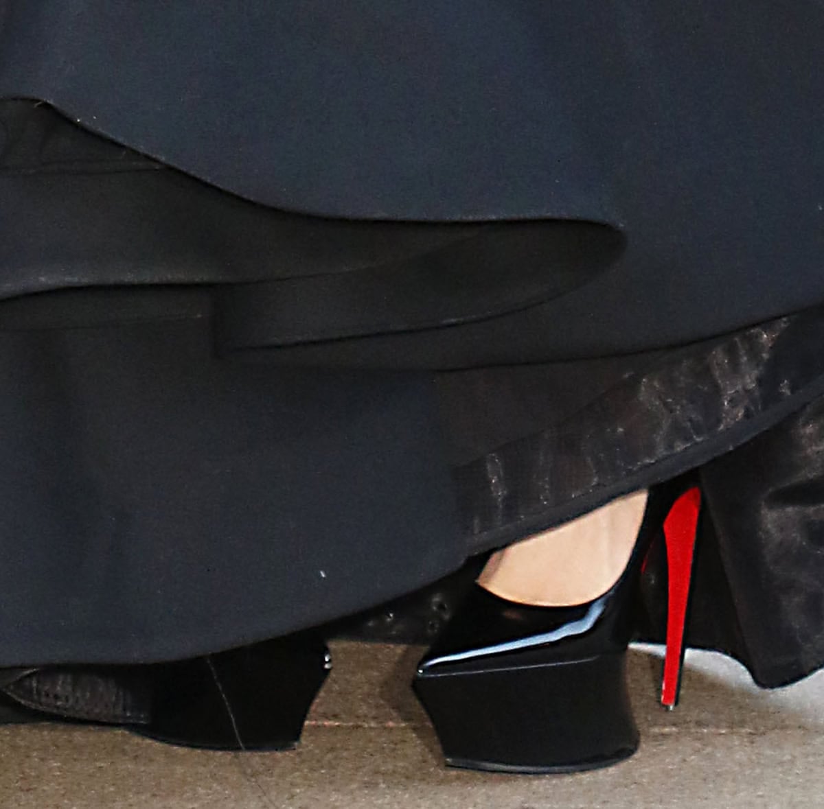 Lady Gaga brings her signature edge to the premiere in the Matières Fécales x Christian Louboutin black patent platform pumps with curved heels and sculptural platforms