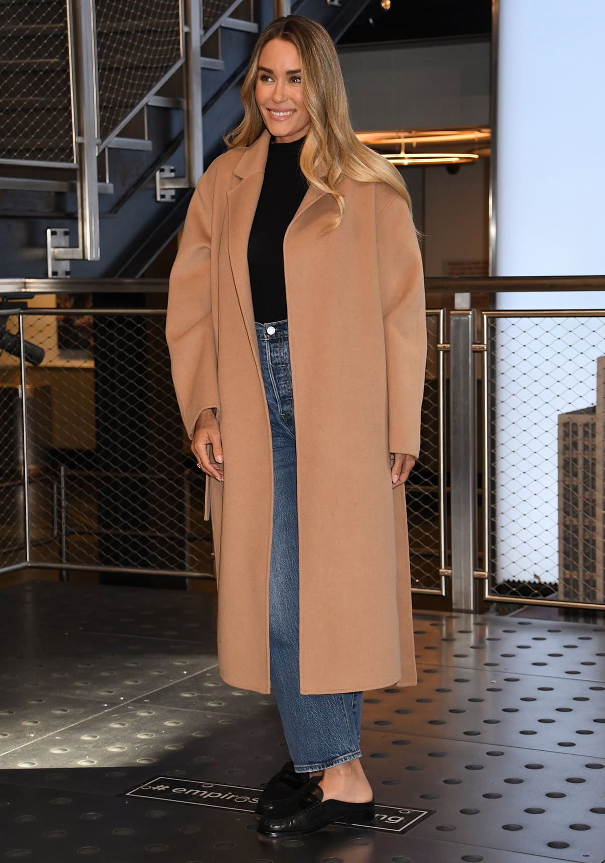Lauren Conrad pairs her comfy mules with casual jeans, a black turtleneck top, and a camel coat