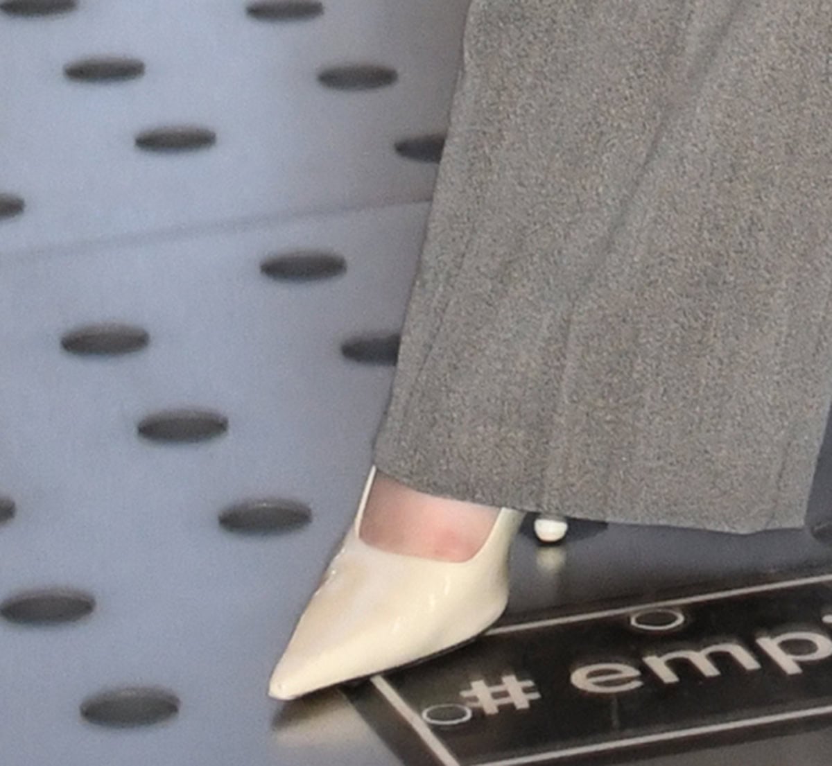 Lucy Halliday adds a hint of charm to her business-ready look with white patent Jimmy Choo “Ixia” pumps with drop heels