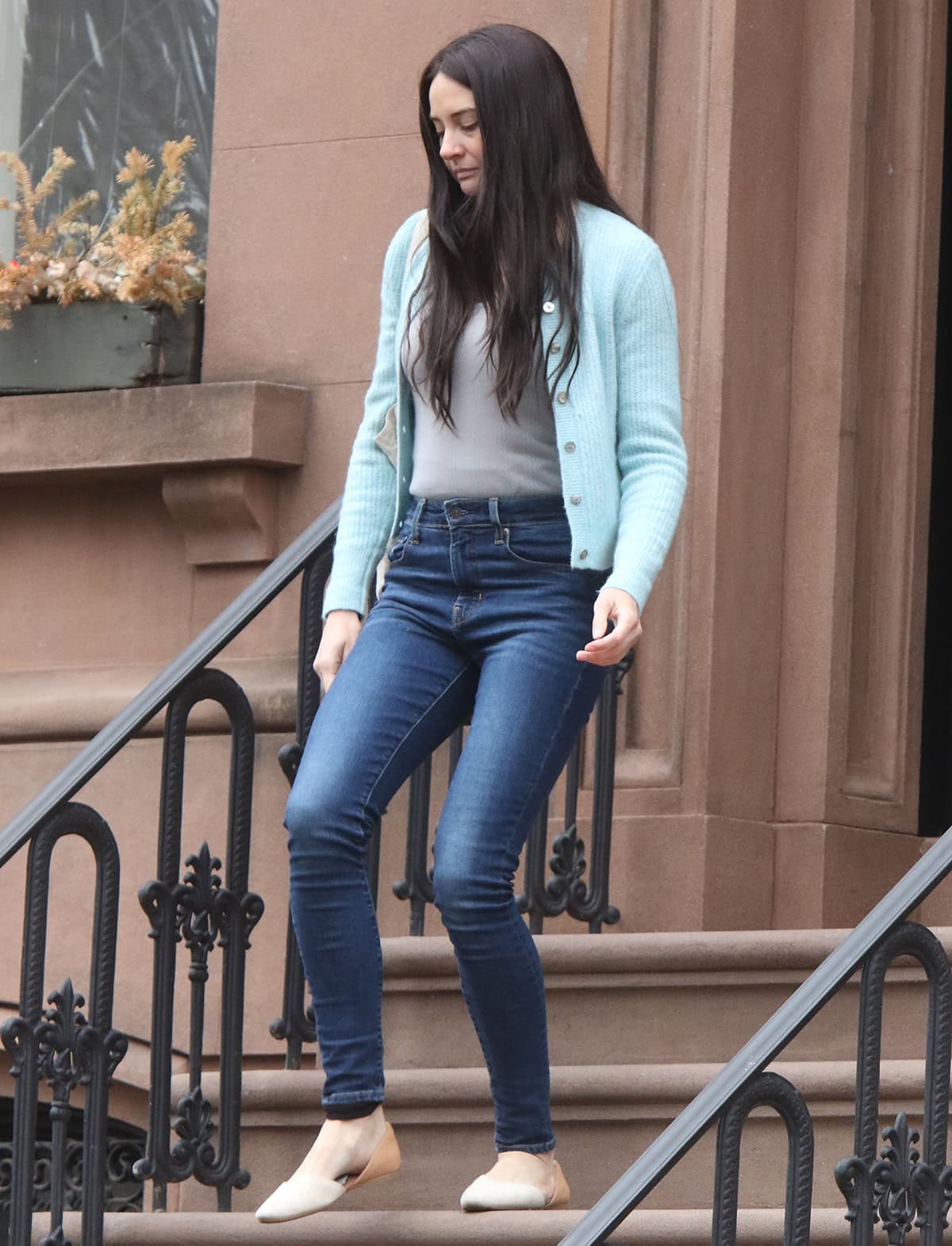 Shailene Woodley wears her Toms flats with dark blue high-waisted skinny jeans, a gray tank top, and a light blue cardigan