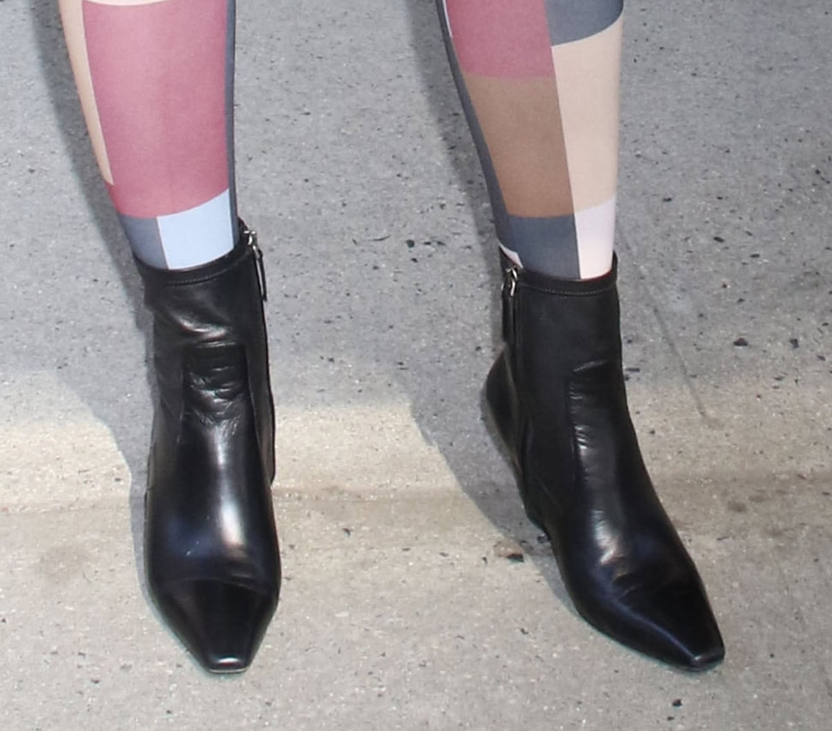 Sharon Stone wears a pair of black leather ankle boots with pointed square toes, side zips, and angled block heels