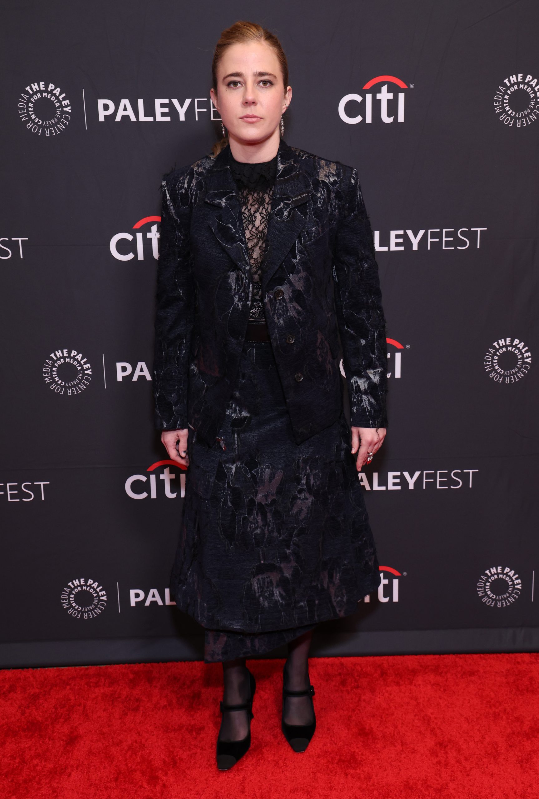 Taylor Dearden teams her black pumps with a jacket and a matching wrap skirt with large-scale floral pattern woven directly into the black jacquard fabric