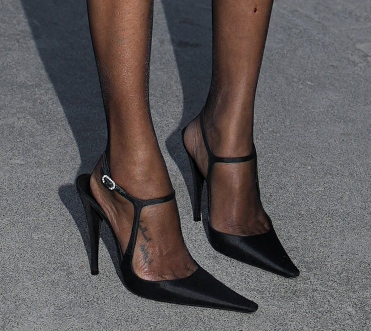 Zoe Saldana slips into the Saint Laurent “Manon” pumps with elongated pointed toes, T-strap sides, an ankle strap with a crystal buckle, and high heels