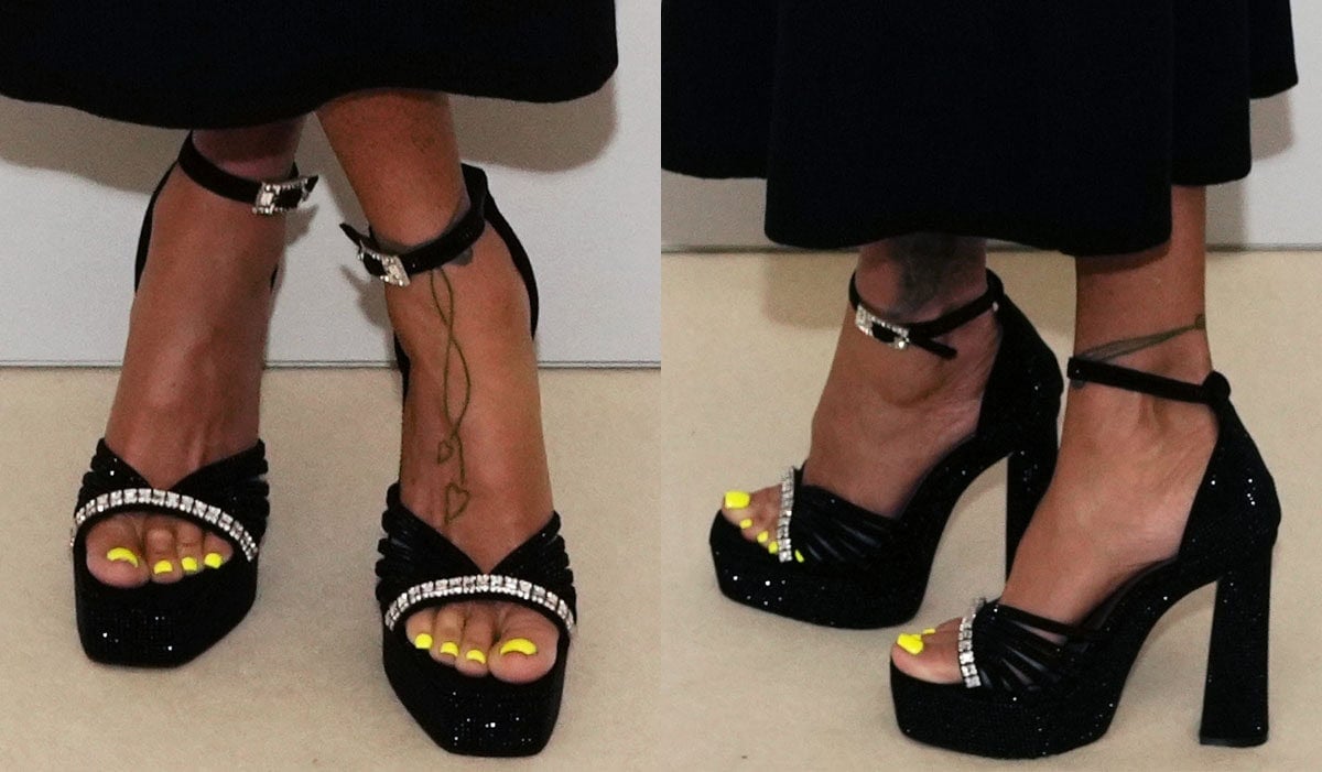 Katie Price showcases her neon yellow pedicure in the black crystal-embellished strappy sandals by Kurt Geiger featuring clear crystals across the toes, ankle straps with a large crystal buckle, chunky platforms, and block heels