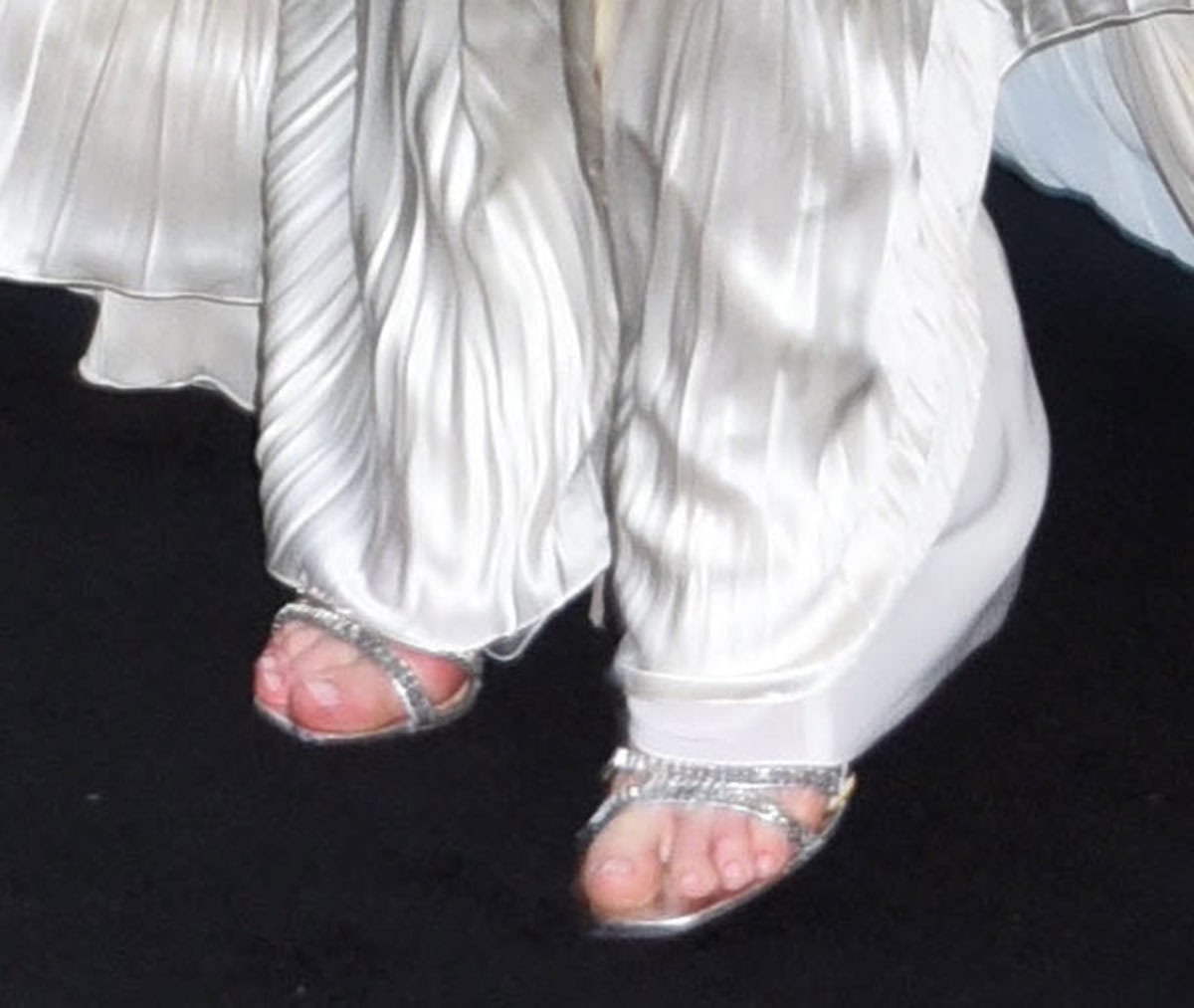 Anne Hathaway shimmers in her silver metallic Prada heels featuring rectangular baguette crystals along the front straps