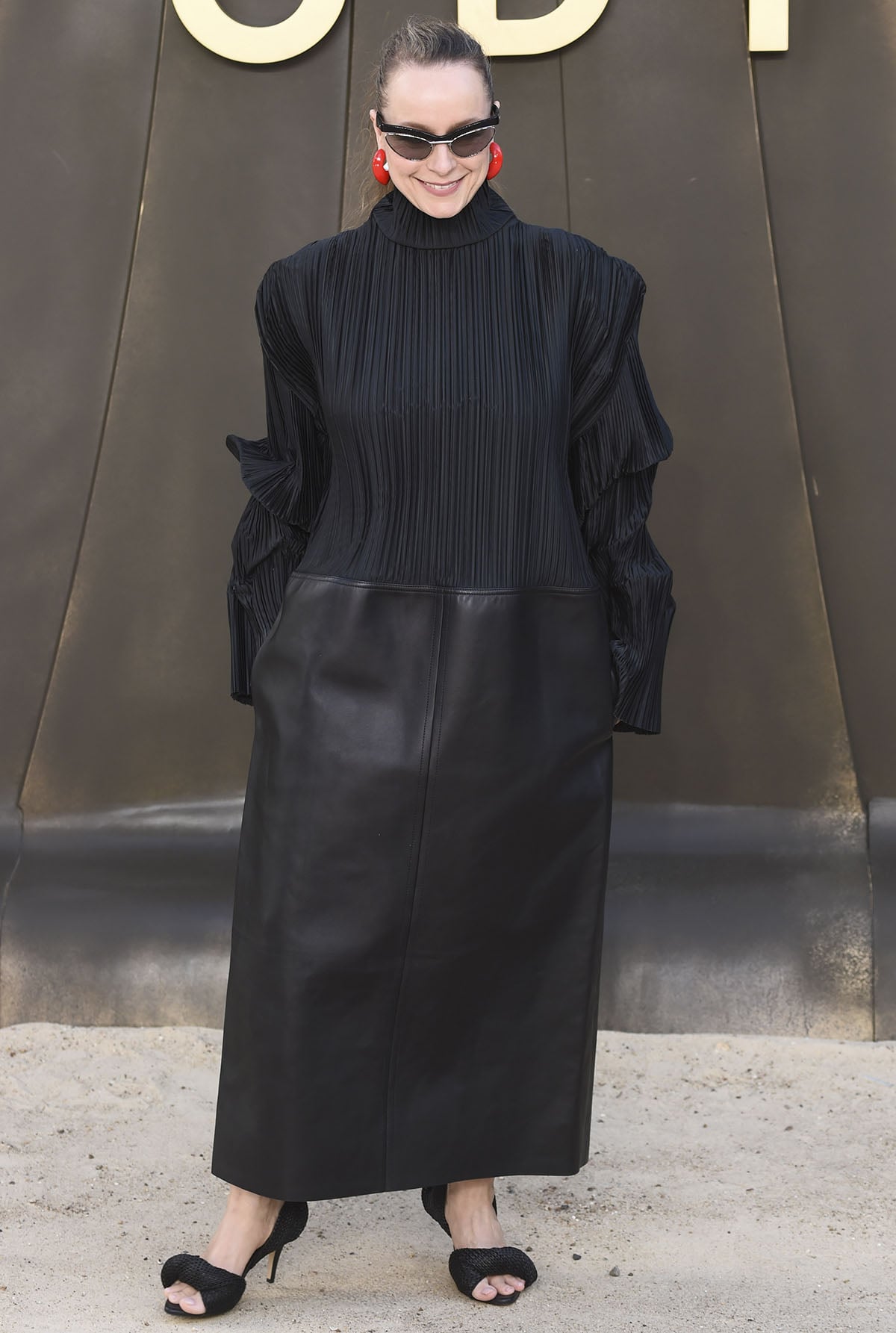 Samantha Morton teams her unique heels with a futuristic Bottega Veneta mixed-media dress featuring a micro-pleated plissé turtleneck top and a heavy, structured matte-black leather maxi skirt